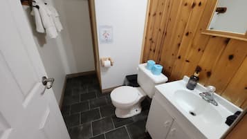 Ein kleines Badezimmer mit Toilette, Waschbecken und Handtuchhalter.