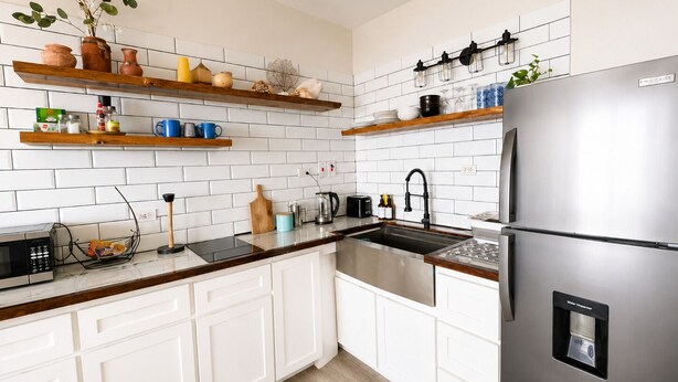 A modern kitchen with white cabinetry, a stainless steel refrigerator, and a variety of kitchen appliances. - Cliffside Caribbean Condo: Beach & Ocean Views (Ocho Rios)