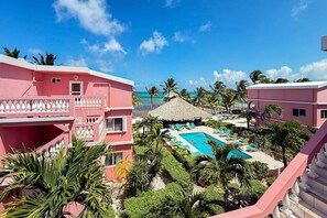 Ein Resort mit Swimmingpool, umgeben von Palmen und Blick auf den Strand.