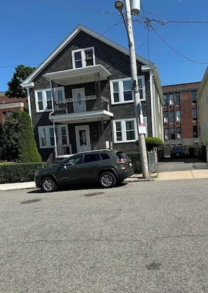 A two-story residential building with a balcony on the second floor.
