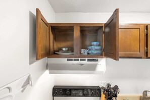 A kitchen with a white stove, wooden cabinets, and a range hood. - UW Hospital Retreat with Dedicated Workspace (Madison)