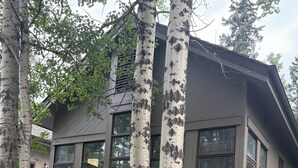 Ein modernes, zweistöckiges Haus mit großen Fenstern und einem geneigten Dach.