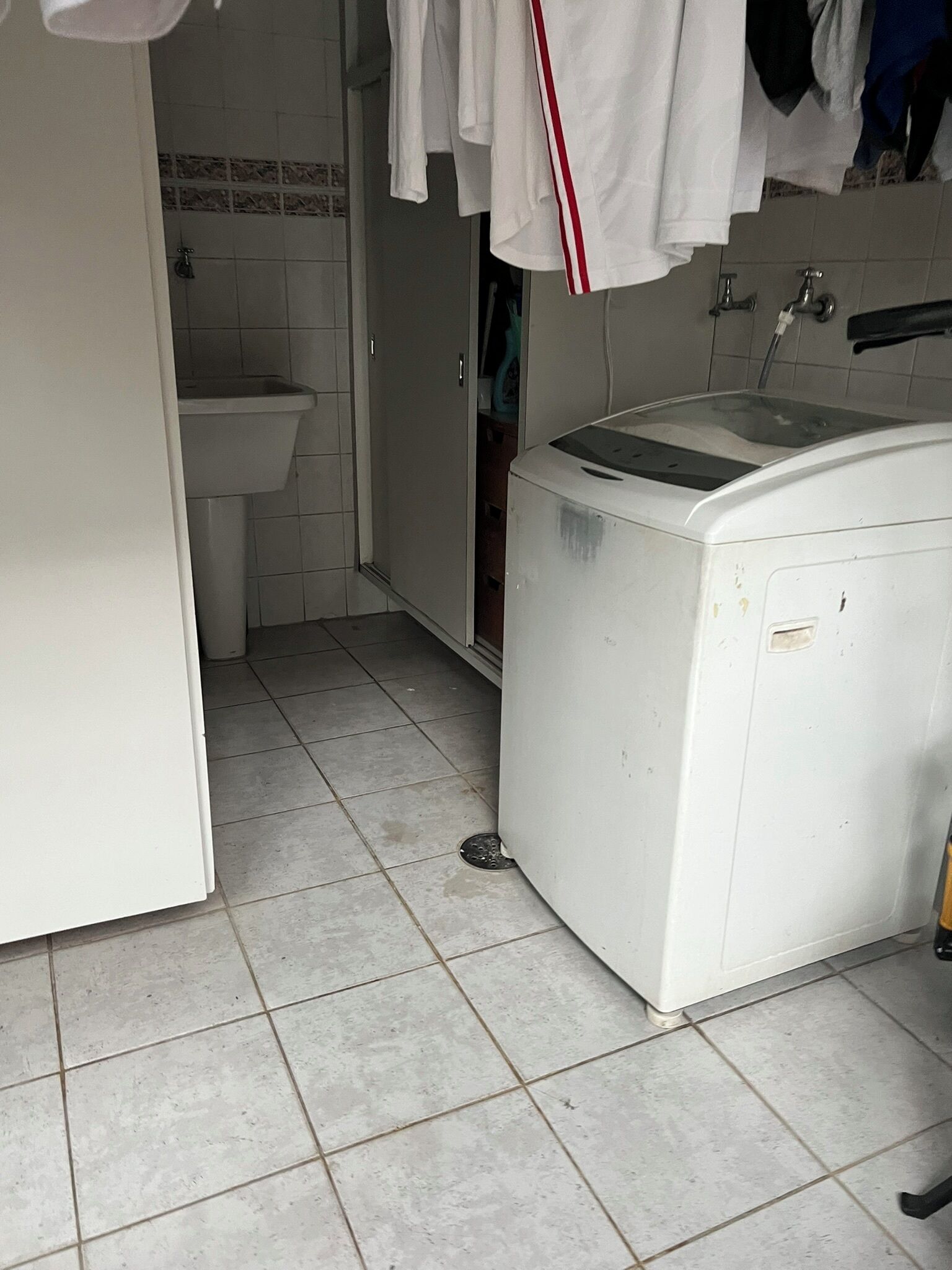 Une petite salle de bain comprenant un lavabo, des toilettes et un lave-linge.