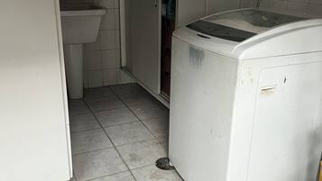 Une petite salle de bain comprenant un lavabo, des toilettes et un lave-linge.