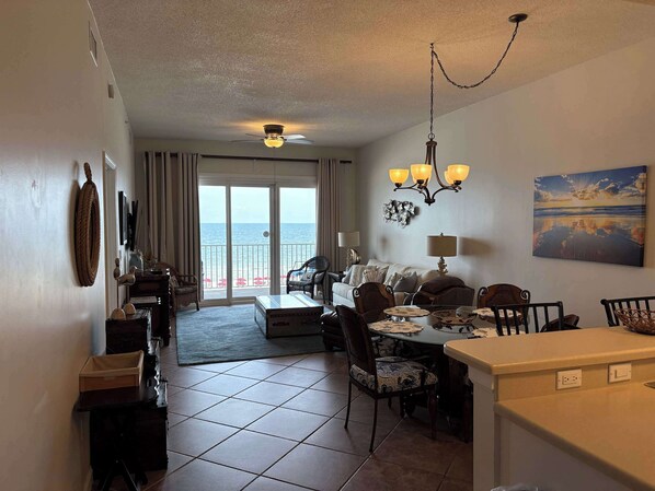 A hotel room with a balcony, dining area, and a view of the sea.