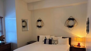 Ein Hotelzimmer mit einem großen Bett, zwei Nachttischen, einer Stehlampe und dekorativen Wandleuchten.