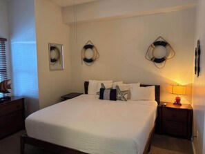 Ein Hotelzimmer mit einem großen Bett, zwei Nachttischen, einer Stehlampe und dekorativen Wandleuchten.