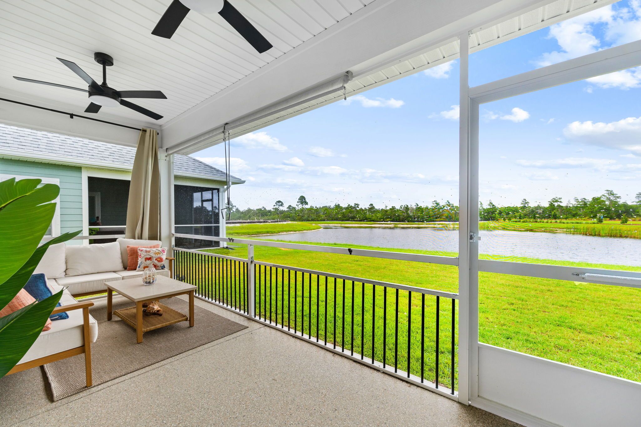 A balcony with a view of a water body and greenery.