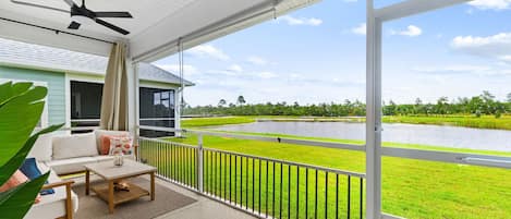 A balcony with a view of a water body and greenery.