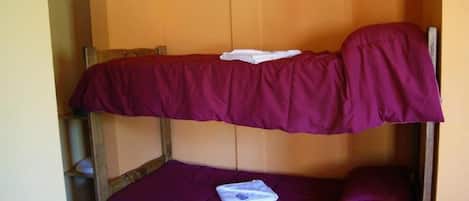 A bunk bed with two levels, each with a purple mattress.