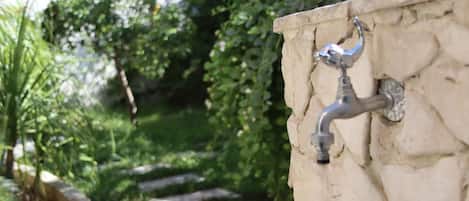 Una pared de piedra con un grifo metálico.