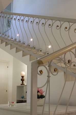 A staircase with ornate metal railings and a handrail. - Gloria (Lucugnano)