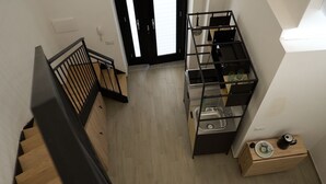 Et moderne køkken med vask i bordpladen, en træbordplade og en sort metalreol.