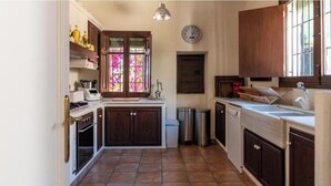 Een keuken met een fornuis, oven, spoelbak en kasten.