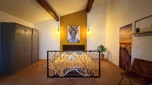 Una habitación con cama, un armario, un cuadro y vistas al atardecer.