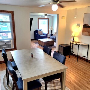 A dining area with a table and chairs, a ceiling fan, and a view into the living room. - Centrally located 3-bedroom house near beach, boardwalk, brewery, bars, and park (Algoma)