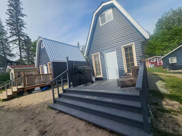 Una casa de dos pisos con un balcón, una parrilla y una puerta principal.