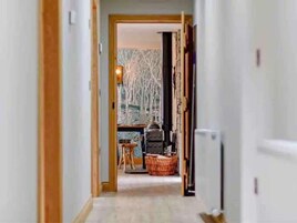 Un pasillo que conduce a una habitación con chimenea, una mesa y una silla.