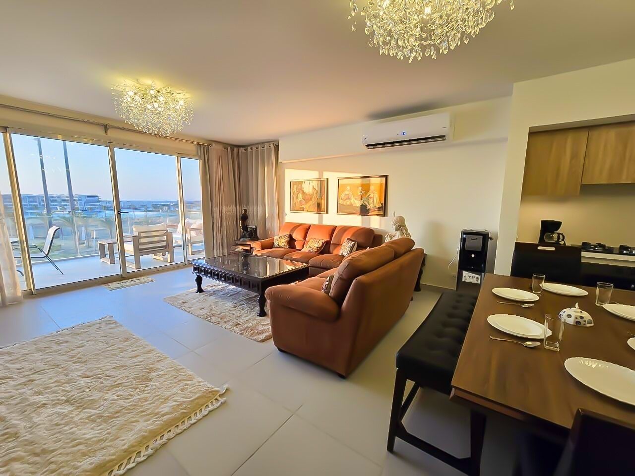 Una sala moderna con sofá, mesa de centro y mesa de comedor lista para cuatro comensales.