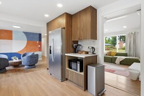 Eine moderne Küche mit Holzschränken, einem Edelstahlkühlschrank und einer Mikrowelle.