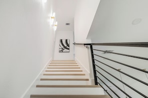 A staircase with a modern design, featuring a wooden handrail and white walls. - Luxury Townhome centrally located Medical Center (Houston)