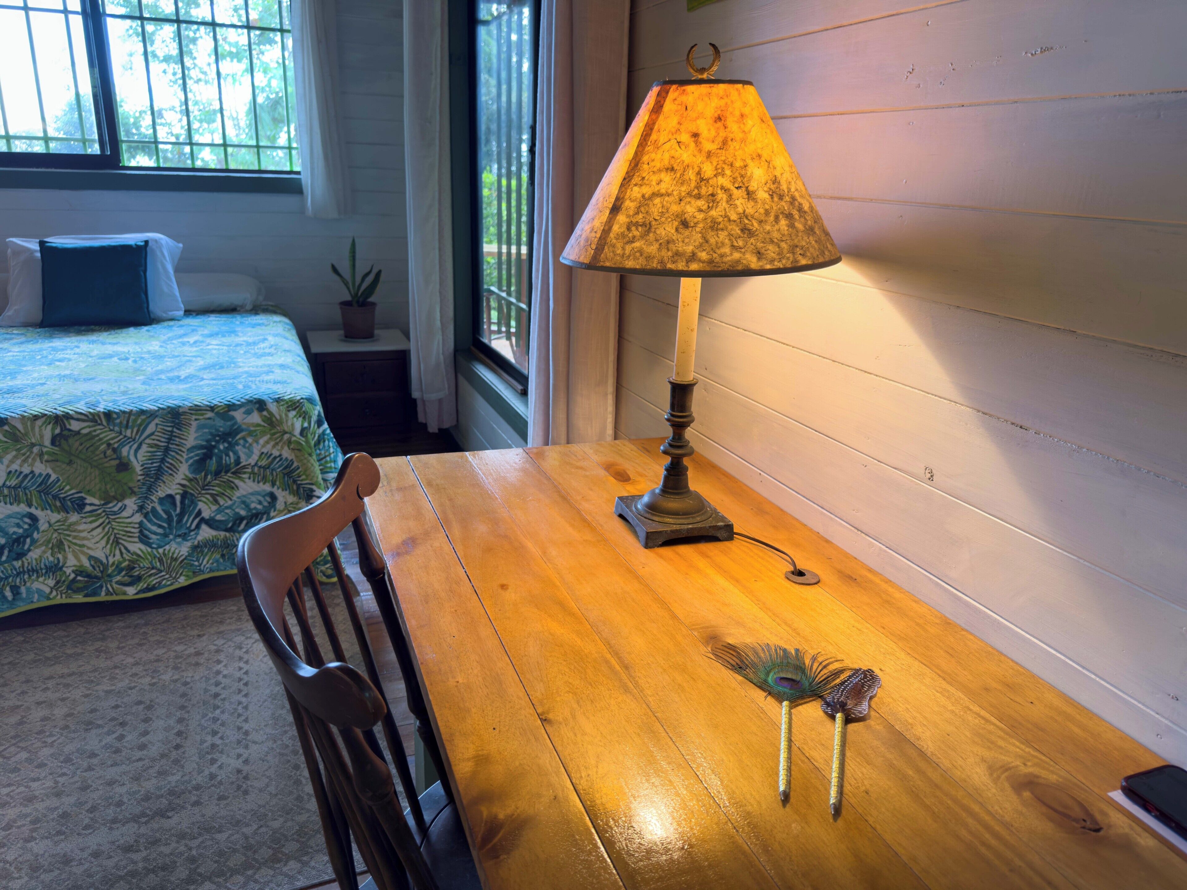 Une table en bois, une lampe, une chaise et des objets décoratifs.