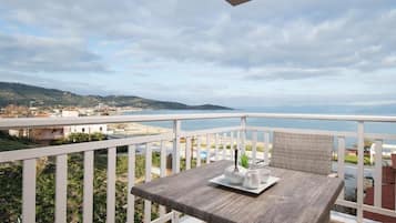 Suíte luxo, sacada, vista parcial para o mar | Opções para refeição ao ar livre