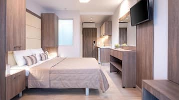Une chambre moderne avec un grand lit, une armoire intégrée et un téléviseur à écran plat.