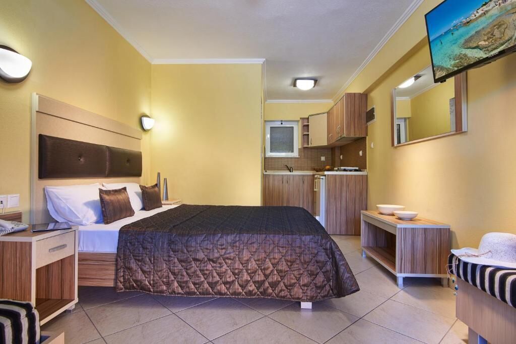Ein Hotelzimmer mit Bett, Nachttisch und Fernseher.