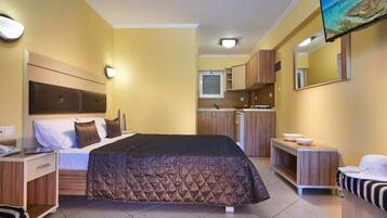 Ein Hotelzimmer mit Bett, Nachttisch und Fernseher.