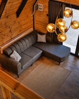 Un interior moderno con un sofá modular, un tapete estampado y una lámpara esférica original.