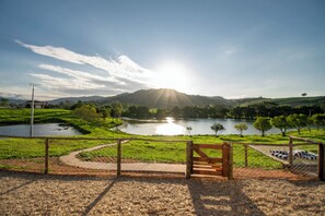 Un parc avec un banc, une clôture et un lac.