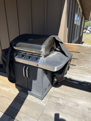 Een barbecue met deksel, handvat en bedieningspaneel met knoppen.