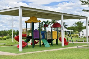 A covered playground with various play structures including slides and climbing elements.