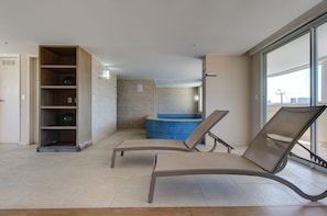 Uma casa de banho moderna com banheira, chuveiro e uma unidade de prateleiras embutida.