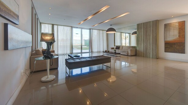 A spacious living room with a modern design, featuring a glass coffee table, a sofa, and a lamp. - Beach Village #1205 - Sea View by Carpediem (Fortaleza)