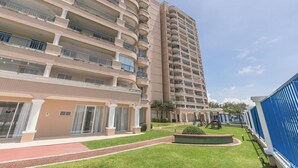A multi-story hotel with balconies, a central courtyard, and a pool area. - Beach Village #1205 - Sea View by Carpediem (Fortaleza)