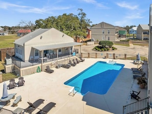 A residential property with a swimming pool, lounge chairs, and a covered patio area. - NEW! Beachfront Condo! 2 MasterSuites! Gulf Views! (Long Beach)