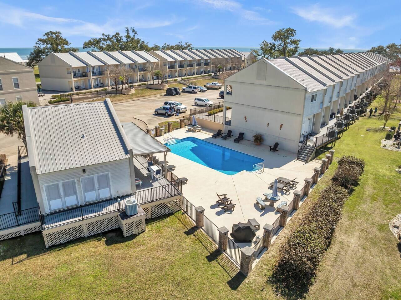 A hotel with a swimming pool, outdoor seating, and a view of the ocean.