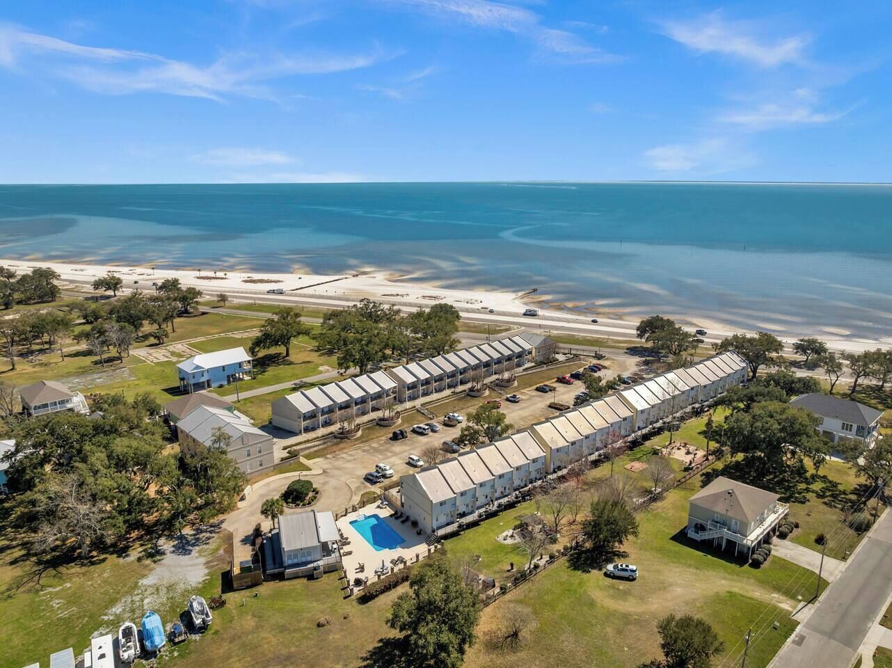 Un gran hotel con varias construcciones, una piscina y vista a la playa.