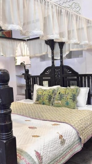 A bed with a canopy, a headboard, and a quilted bedspread. - Premium Heritage House (hiran magri udaipur)
