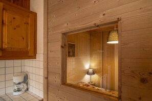 Ein Holzblockhaus-Innenraum mit Fenster, Lampe und Kaffeemaschine.