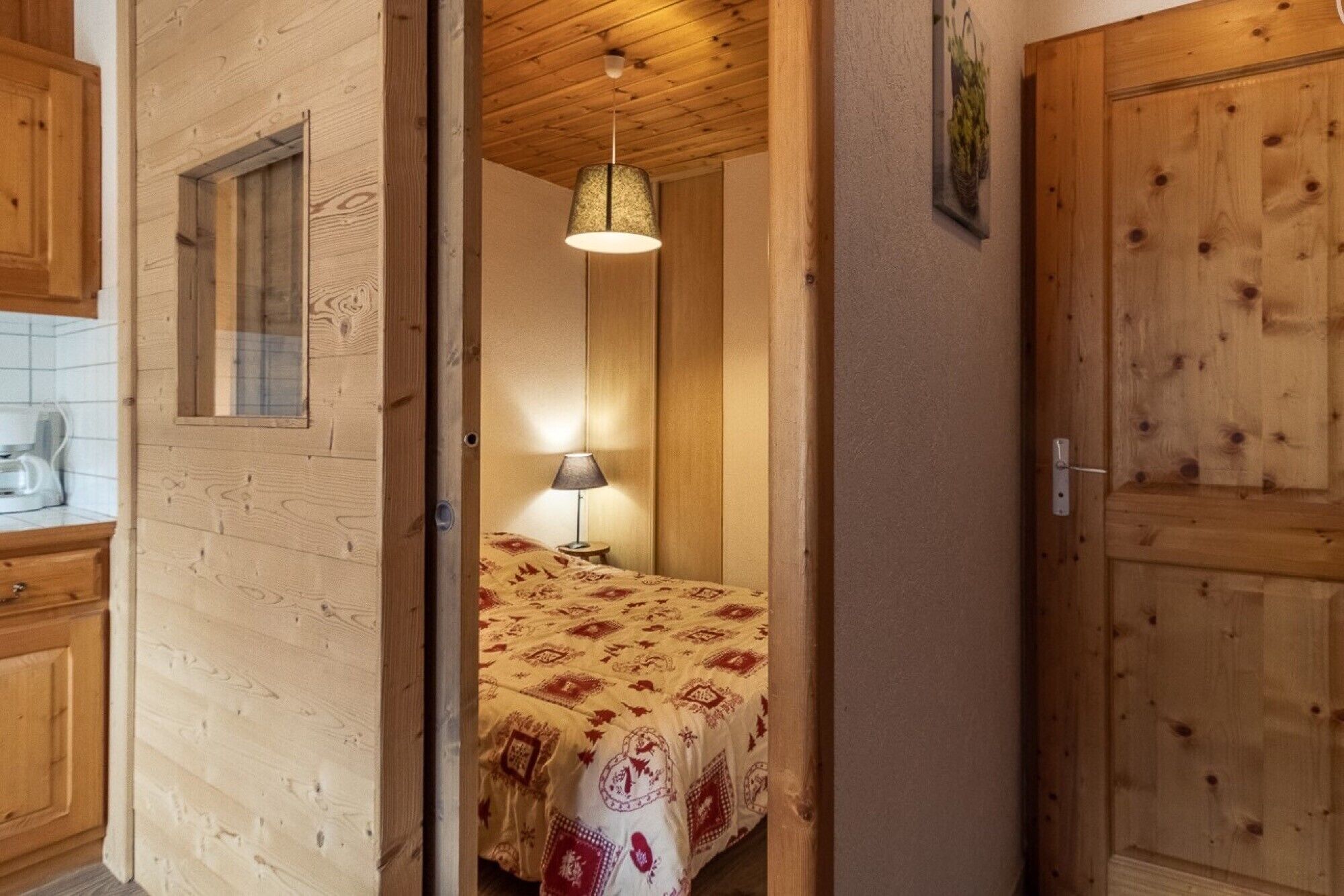 Ein Zimmer mit Holzeinrichtung, einem Bett, einer Lampe und einem Fenster.