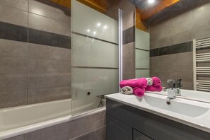 A bathroom with a glass shower enclosure, a white sink, and a towel rack with pink towels. - Les Balcons de St So Apartment A – 6/7 Guests, Ski-in/Ski-out, Mountain View, Parking (Saint-Sorlin-d'Arves)