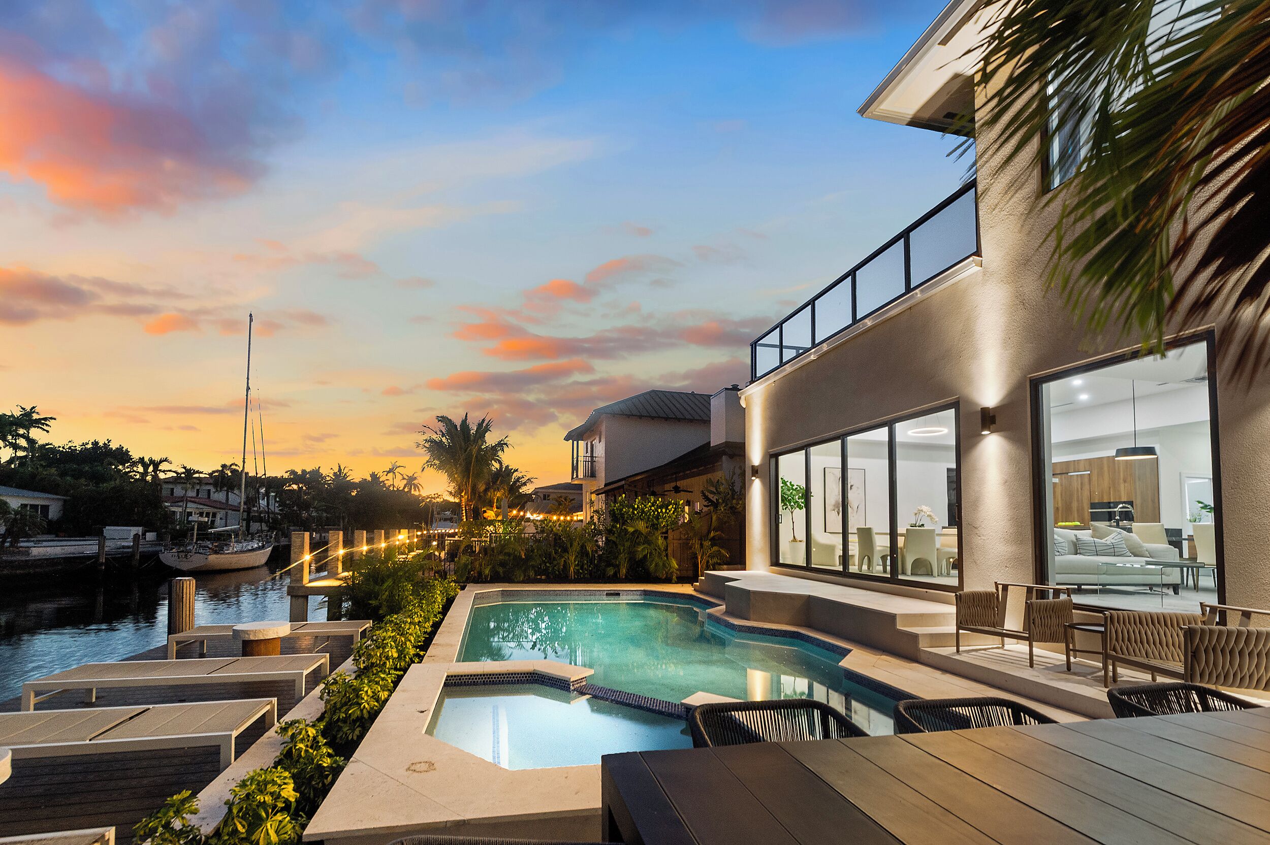 A modern building with a swimming pool, outdoor seating, and a view of the marina.