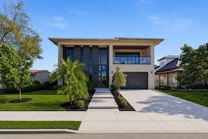 A modern two-story house with a large garage, a covered front porch, and a well-maintained lawn. - Luxury House Waterfront Intracoastal Access (Fort Lauderdale)