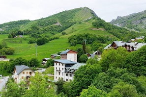 A hillside village with traditional buildings, a clear road, and a mountain in the background. - Les Balcons de St So Apartment B – 3 Bedrooms, Ski-In/Ski-Out, Sleeps 8 (Saint-Sorlin-d'Arves)