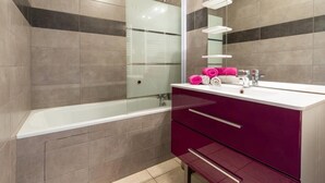 A modern bathroom with a glass shower enclosure, a white bathtub, and a vanity with a mirror. - Les Balcons de St So Apartment C – 8 Guests, Ski-In/Ski-Out, Mountain View, 3 Bedrooms (Saint-Sorlin-d'Arves)