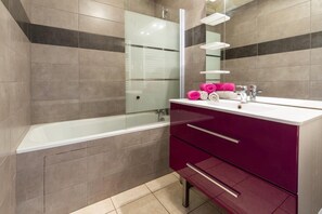 A modern bathroom with a glass shower enclosure, a white bathtub, and a vanity with a mirror. - Les Balcons de St So Apartment C – 8 Guests, Ski-In/Ski-Out, Mountain View, 3 Bedrooms (Saint-Sorlin-d'Arves)