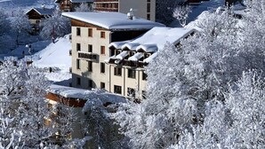 A multi-story building with a snow-covered roof and surrounding trees. - Les Balcons de St So Apartment C – 8 Guests, Ski-In/Ski-Out, Mountain View, 3 Bedrooms (Saint-Sorlin-d'Arves)